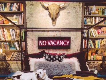Small bedroom decorating ideas - bookshelves, skull and neon sign